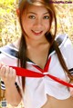 A woman in a sailor outfit holding a red ribbon.